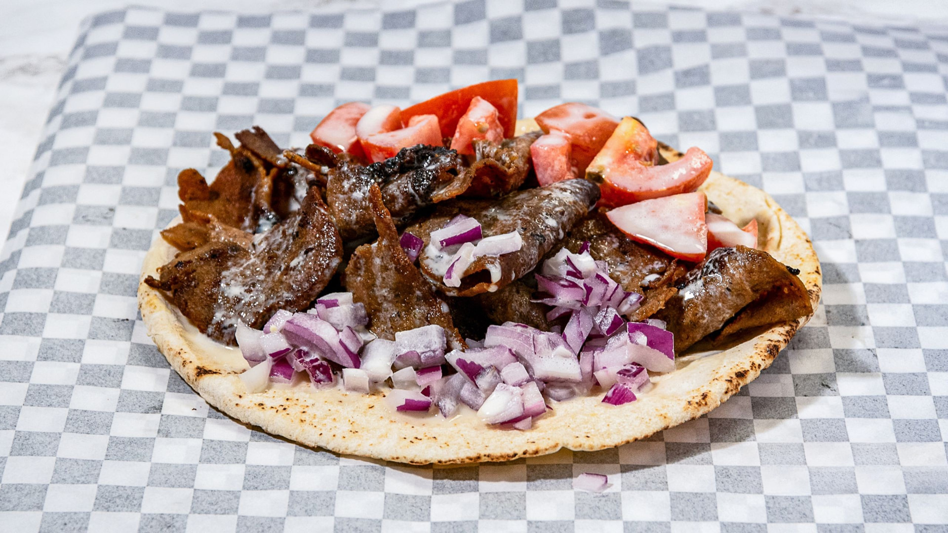 Supreme donair loaded with sliced donair meat, onions and tomato on a pita